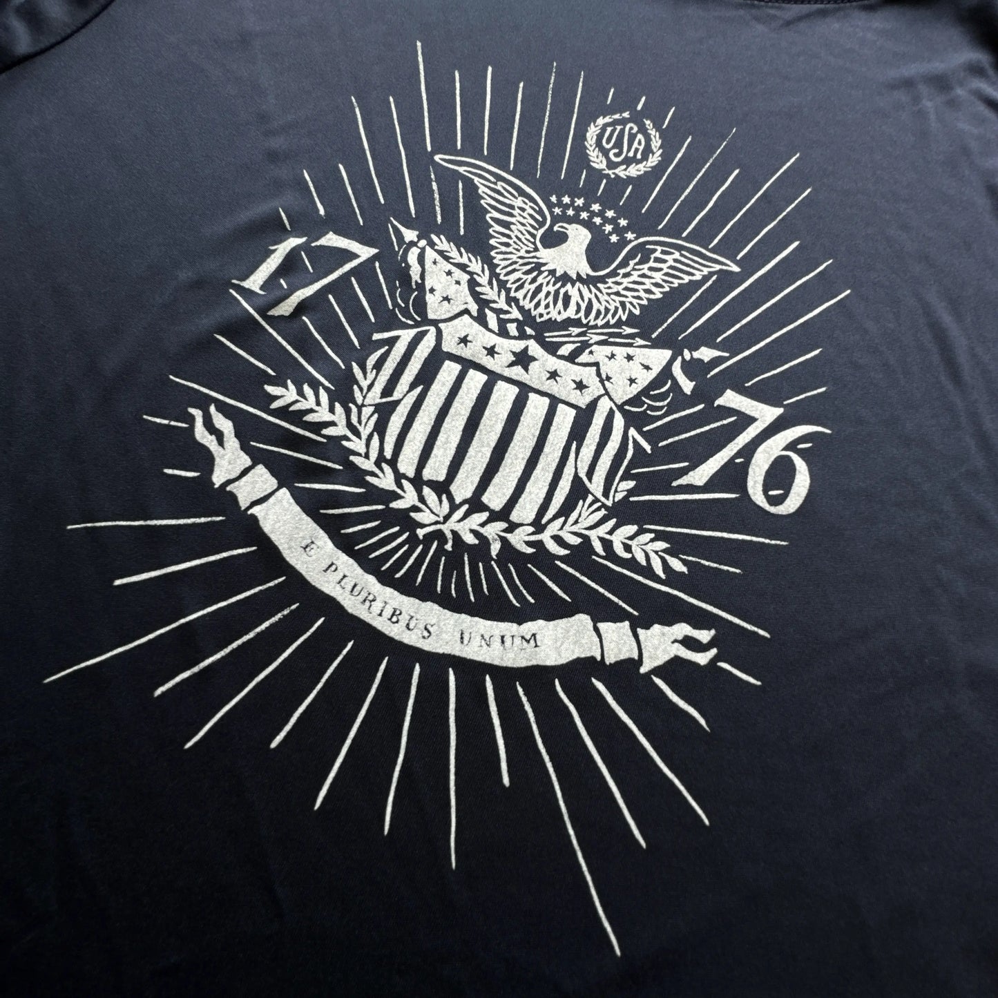 Close-up of the 1776 "E Pluribus Unum" on moisture-wicking 100% polyester interlock with SPF 40+ UV protection - Long-sleeved from The History List Store.