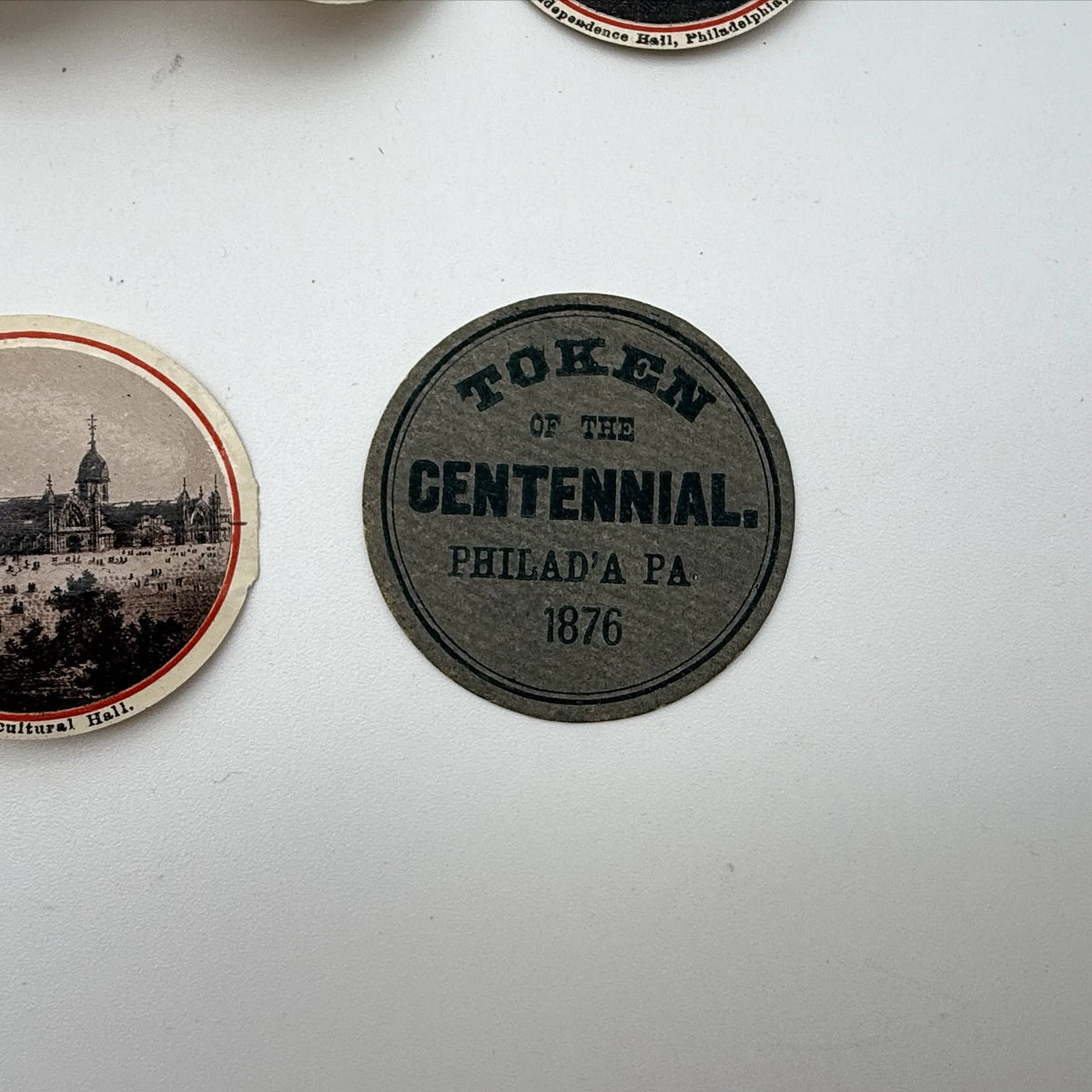 Centennial "token" with 14 small photos of Philadelphia historic sites enclosed