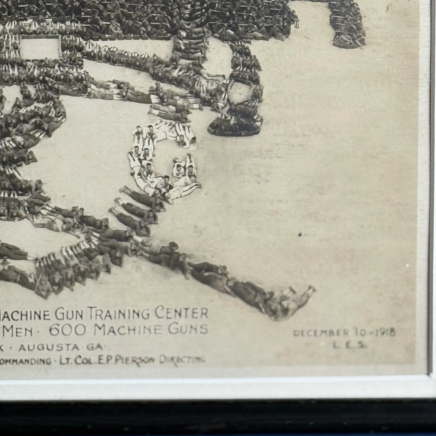 Close-up, lower left, of the WWI 'Machine Gun Insignia' original photograph with 22,500 officers and men alongside 600 machine guns — 1918, from The History List Store
