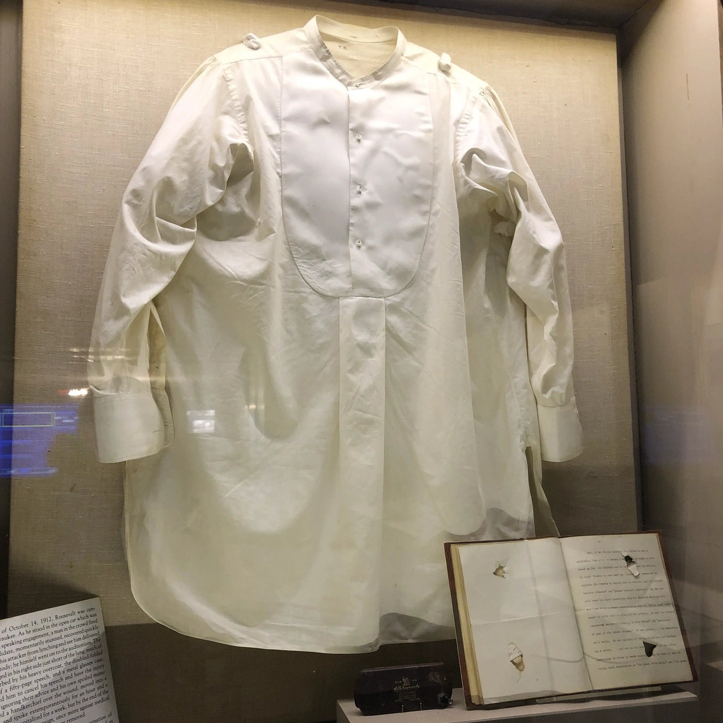 Photo taken by Lee, the recreated boyhood home of Roosevelt in New York that show the shirt, speech (now bound), and glasses case that slowed the bullet when Roosevelt was shot as he was arriving to give a speech in Milwaukee.