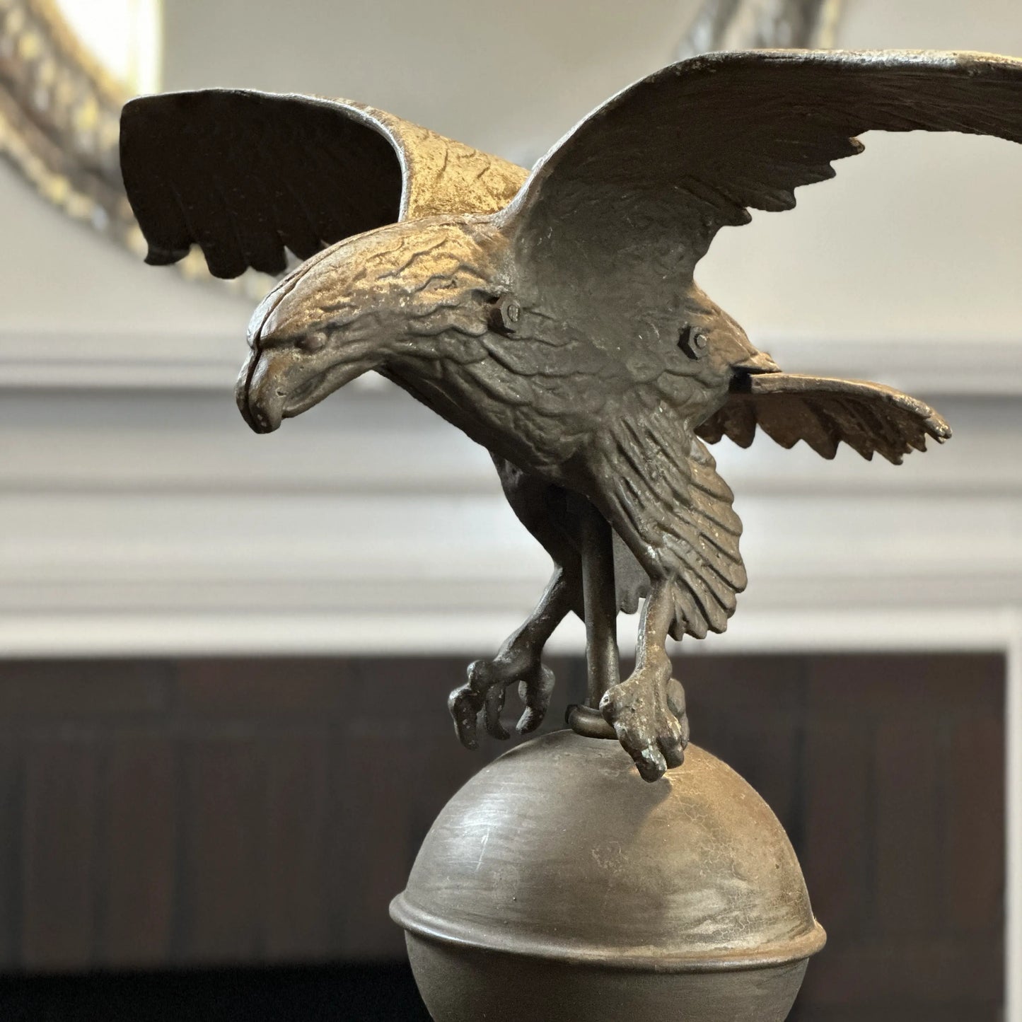 Mounted metal eagle atop a ball and wooden base