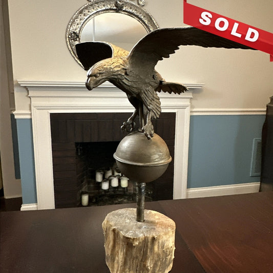 Mounted metal eagle atop a ball and wooden base