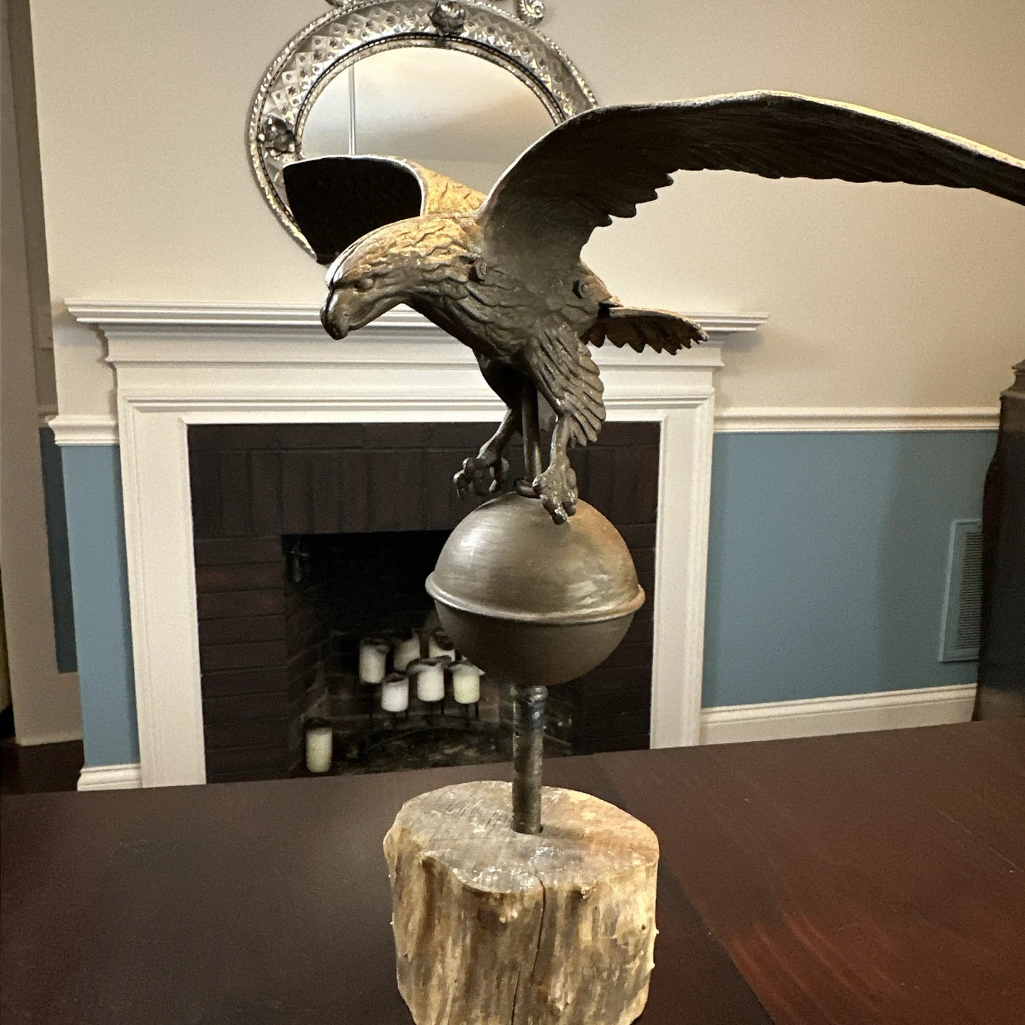 Mounted metal eagle atop a ball and wooden base
