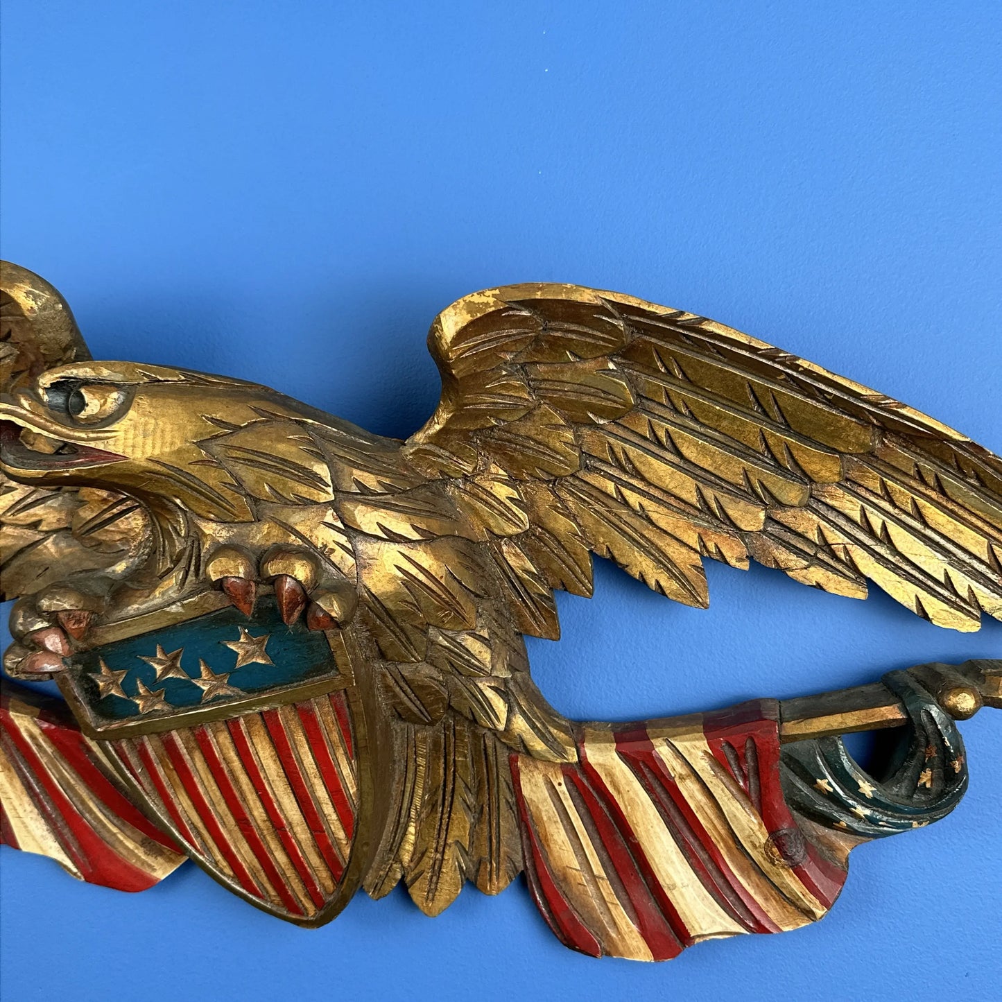 Carved wooden eagle with a shield and two flags — 29” wide