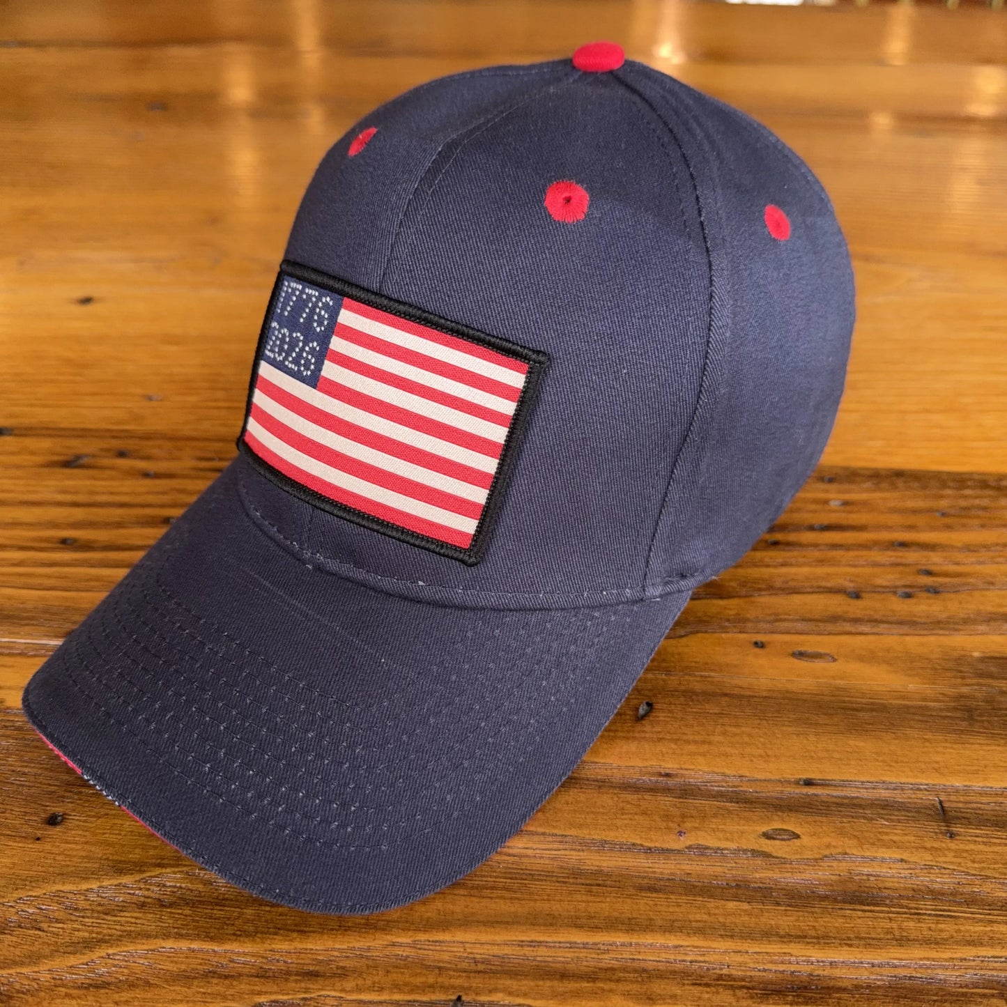 1776 - 2026 "Let Freedom Ring" cap — Dark blue with flag brim