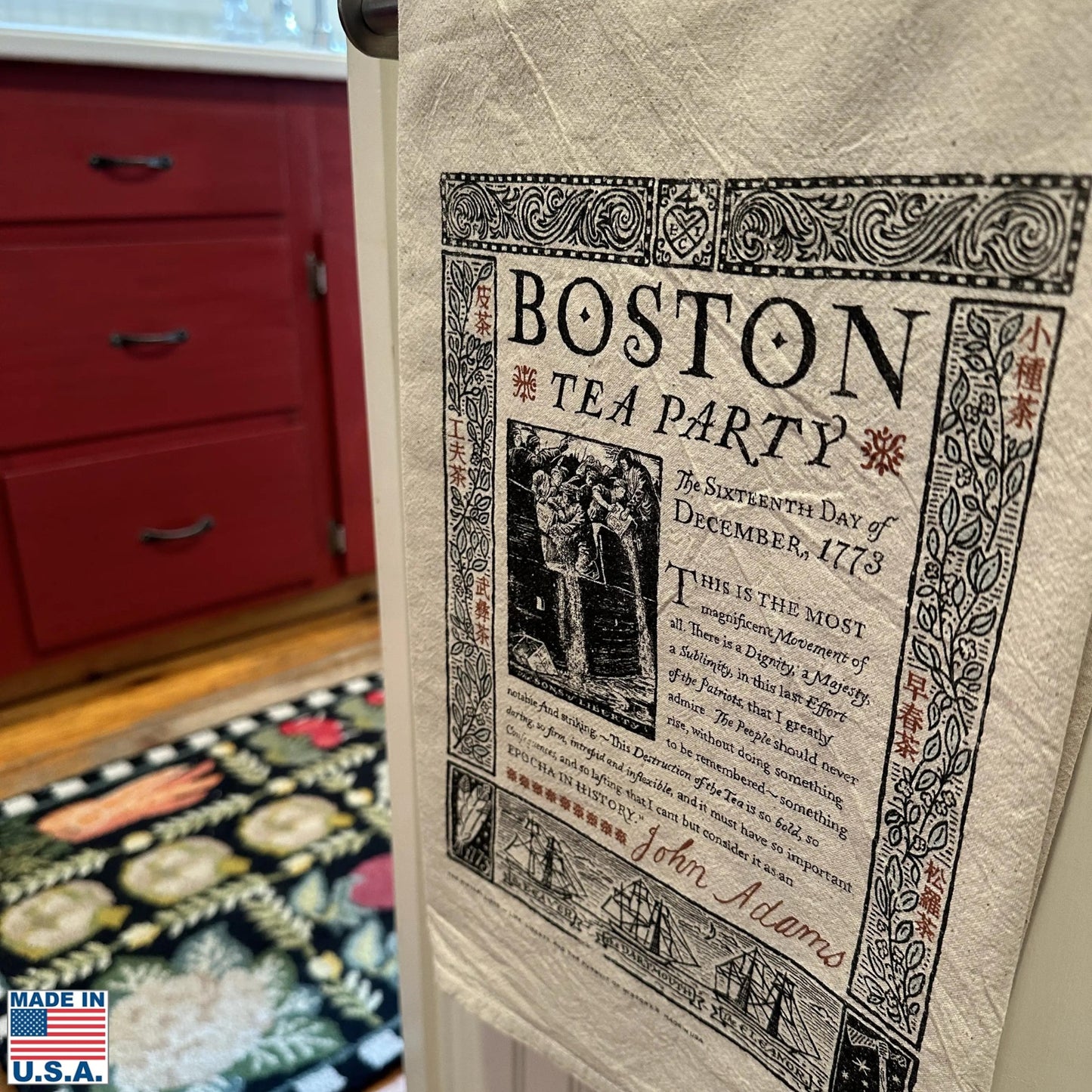 Boston Tea Party 250th Anniversary Tea Towel — Made in America hanging in a kitchen rod from The History List store