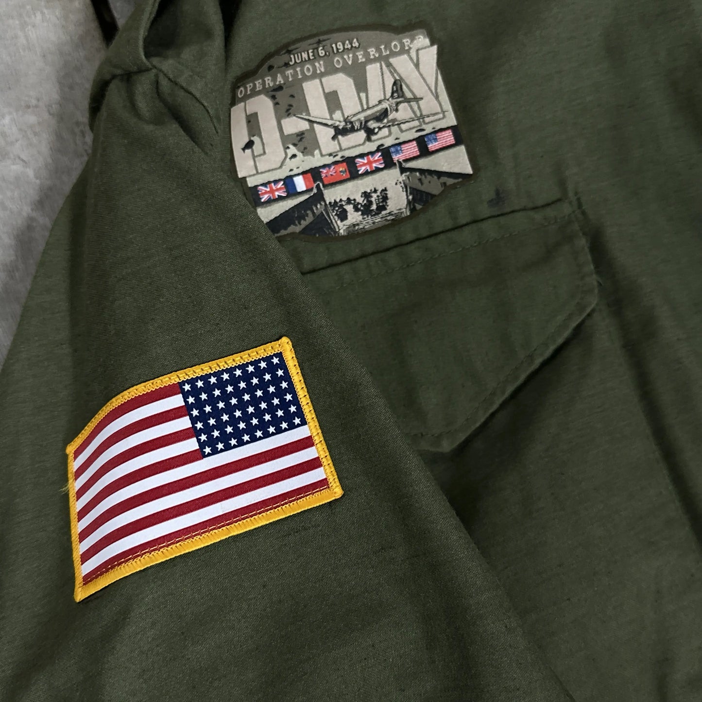 M65 Army field coats with original D-Day Operation Overlord design and a 48-star flag