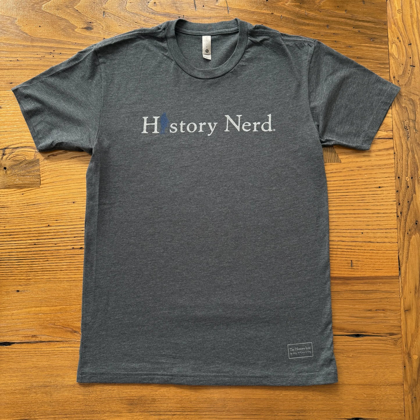 Gray t-shirt with 'History Nerd' text on a wooden surface from The History List store