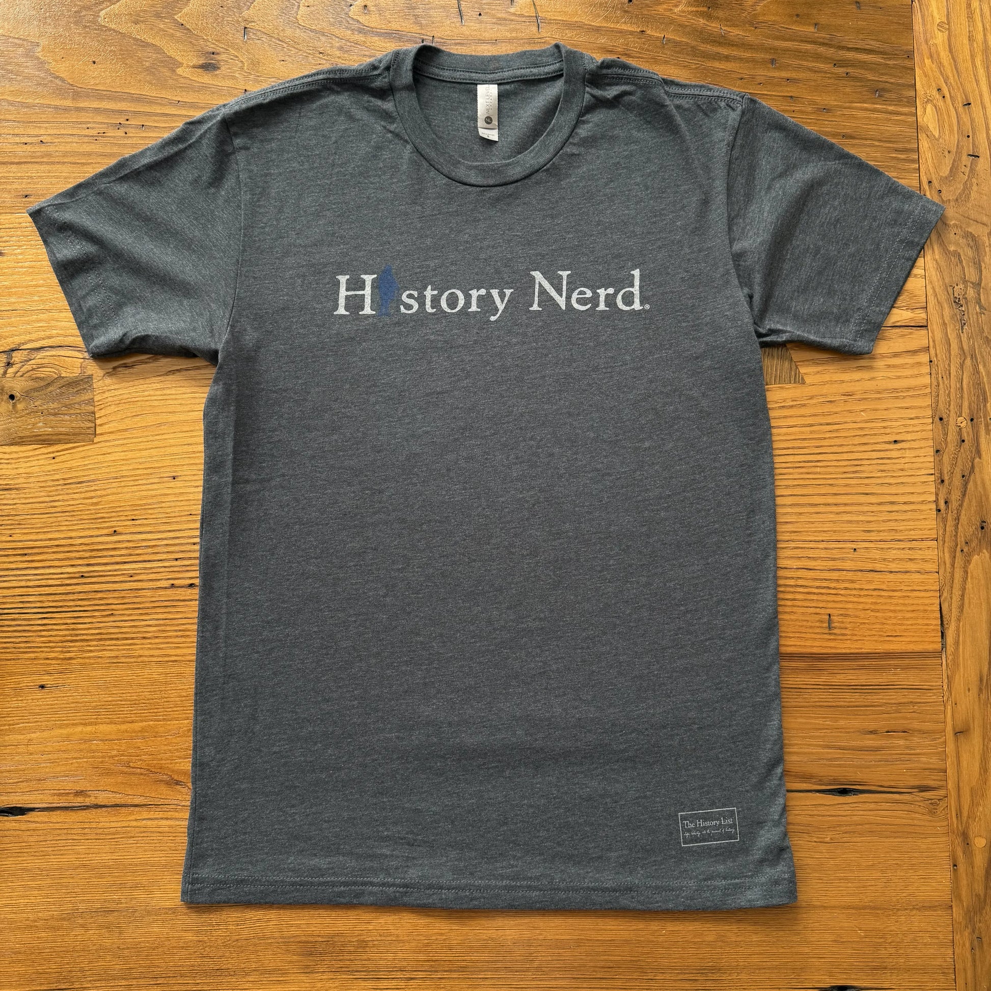 Gray t-shirt with 'History Nerd' text on a wooden surface from The History List store