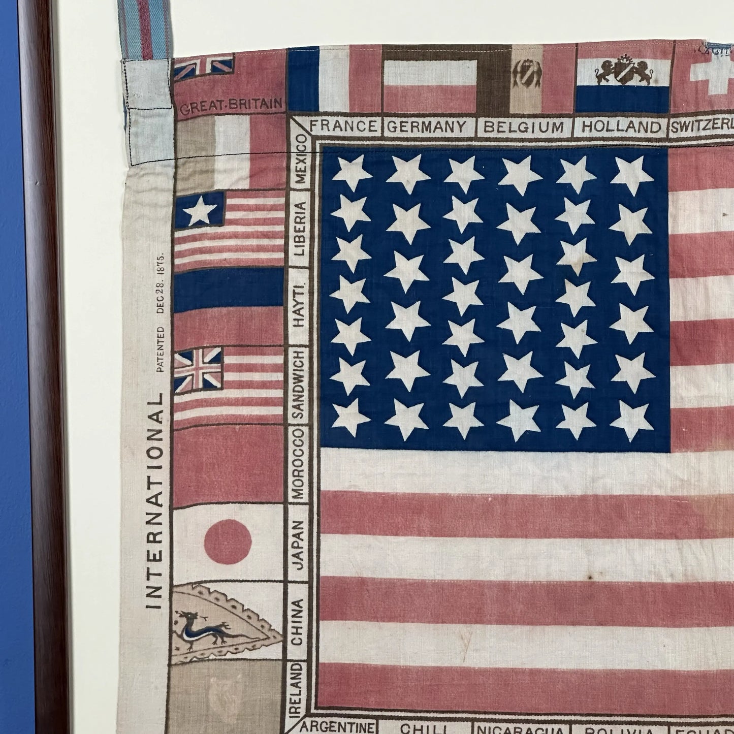 Printed for the 1875 Centennial Exhibition: US flag surrounded with the flags of participating nations — Framed