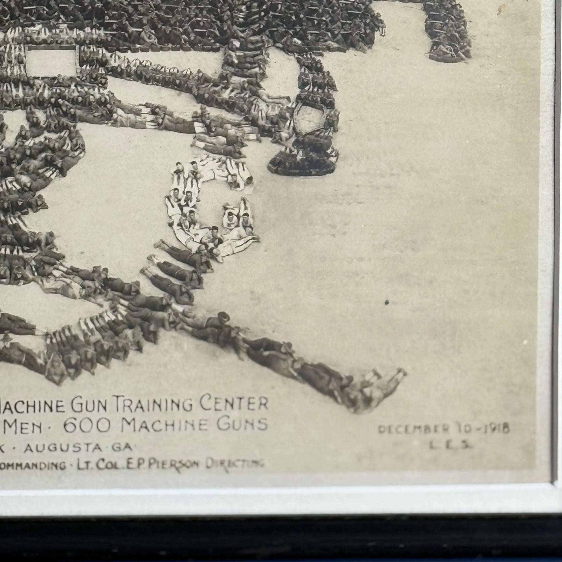 Close-up, lower left, of the WWI 'Machine Gun Insignia' original photograph with 22,500 officers and men alongside 600 machine guns — 1918, from The History List Store