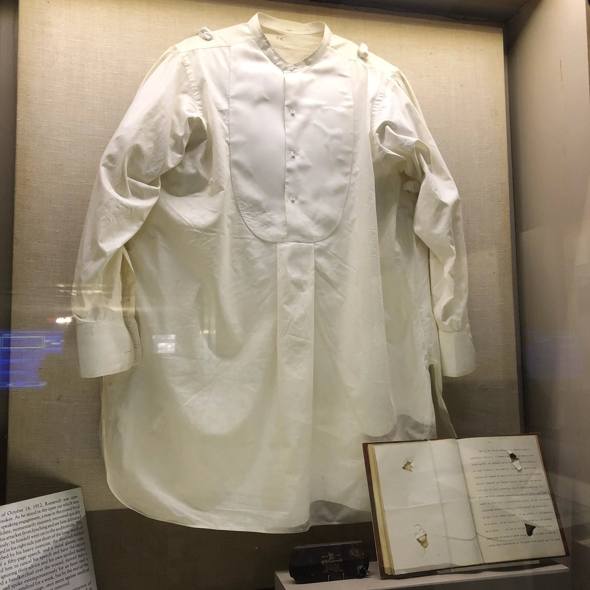 Photo taken by Lee, the recreated boyhood home of Roosevelt in New York that show the shirt, speech (now bound), and glasses case that slowed the bullet when Roosevelt was shot as he was arriving to give a speech in Milwaukee.