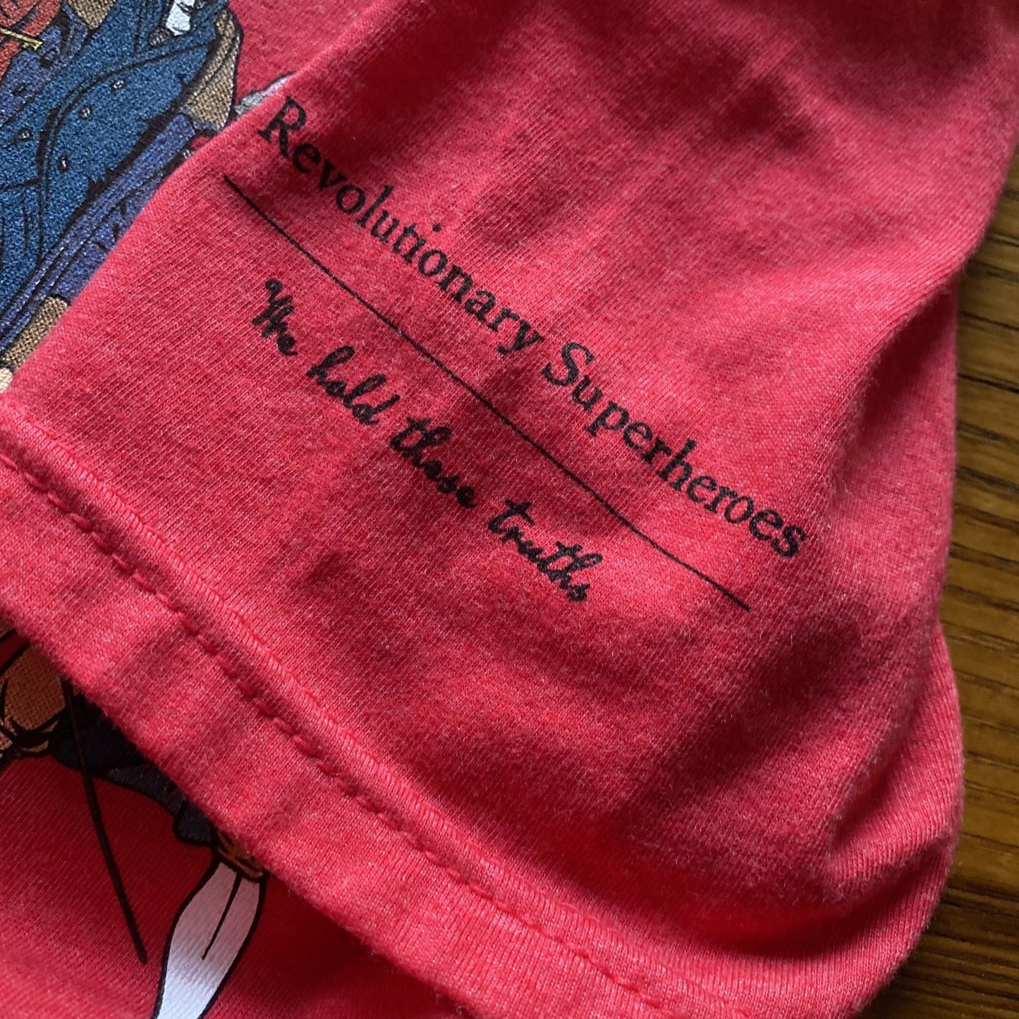 Close-up of sleeves of Ten "Revolutionary Superheroes" Shirt in Youth sizes from The History List store